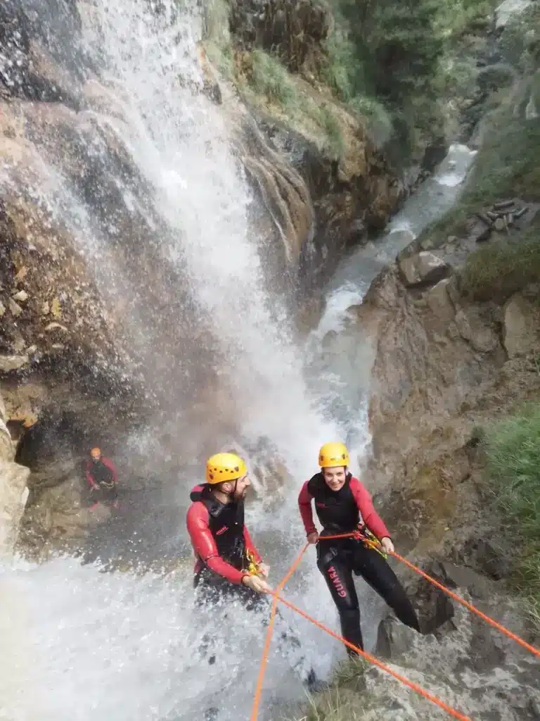 Deux personnes descendent en rappel une cascade du canyon de la blache