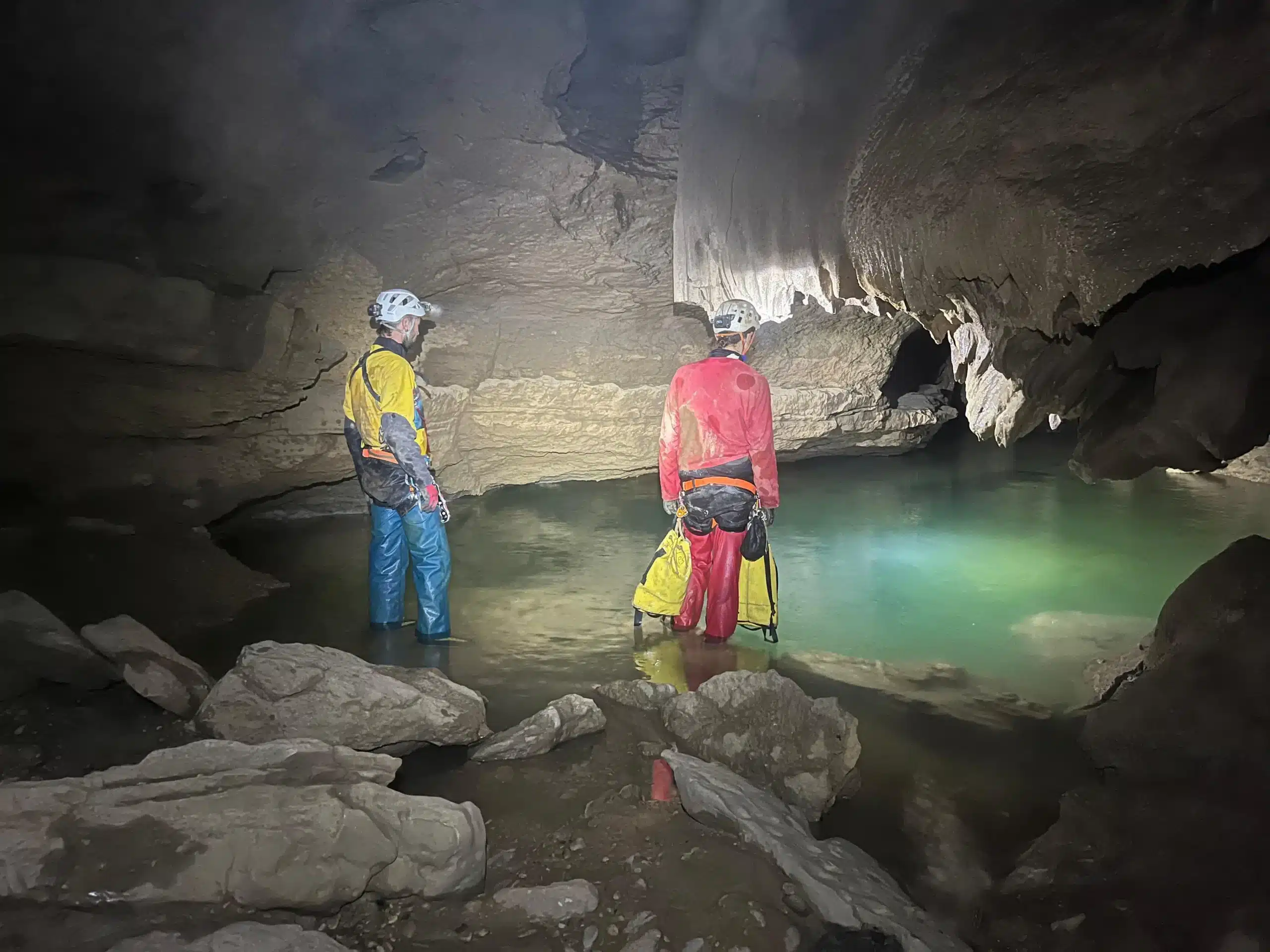 Spéléologie dans les Hautes-Alpes. avec deux personnes qui visitent une rivière souterraine.