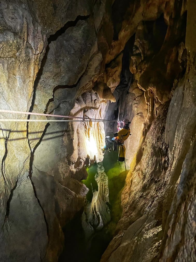Une personne franchit un lac souterrain à laide d'une tyrolienne