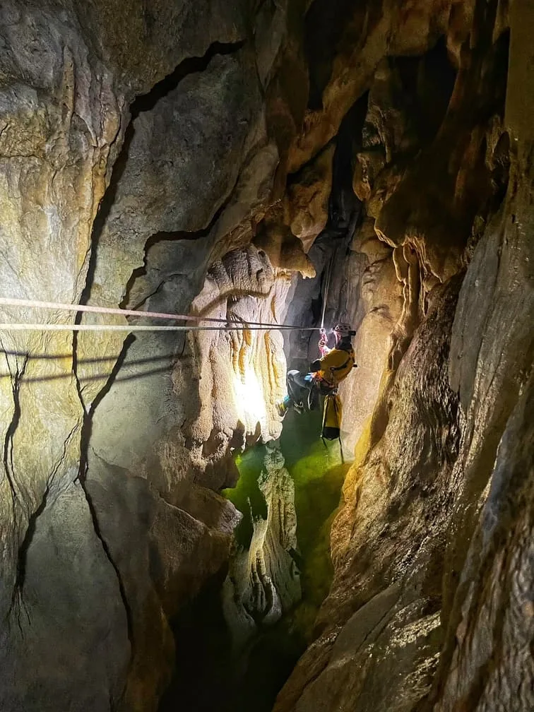 Une personne franchit un lac souterrain à laide d'une tyrolienne