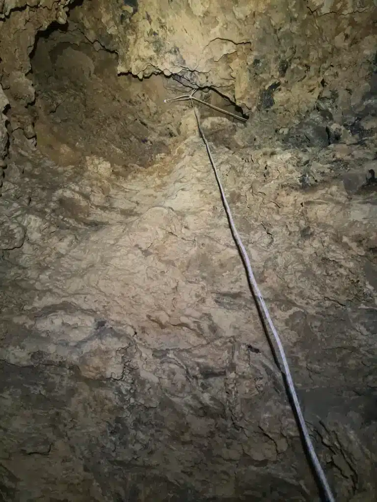 vue depuis le bas sur une corde blanche suspendue au sommet d'un puits