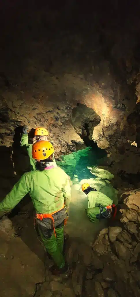 Trois spéléologues assis devant le siphon du Puits des Bans dans le massif du Dévoluy