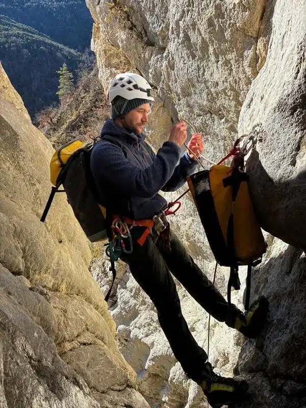 Un guide de canyoning à Orpierre installe une corde au sommet d'une cascade