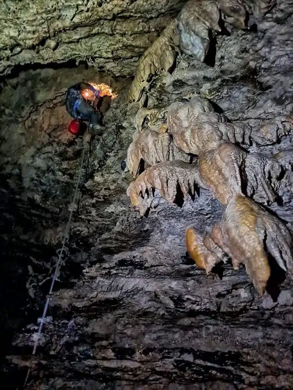 Une personne remonte une corde lors d'une sortie de spéléologie à Super Dévoluy